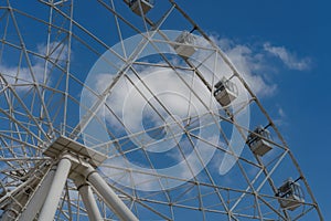Ferris wheel against blue sky and white clouds