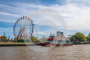 Ferris Wheel, amusement park and ferry boat in Lujan River - Tigre, Buenos Aires, Argentina photo