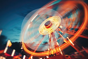 Ferris wheel at amusement park in motion blur, toned image, Abstract blur image of an illuminated Ferris wheel in an amusement