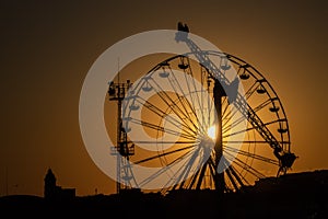 Ferris wheel in amusement park at sunset