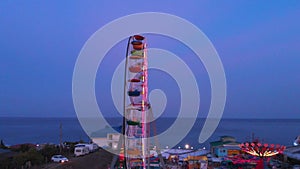 Ferris wheel on the background of the sea at sunset. View from above