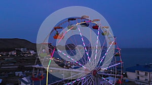 Ferris wheel on the background of the sea at sunset. View from above