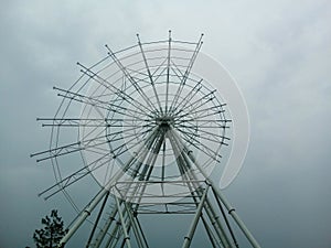 The ferris wheel being built, only half of the structure is assembled.