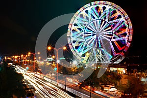 Ferris wheel and blurry night traffic lights