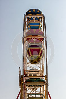 Ferris wheel with booths on blue sky background