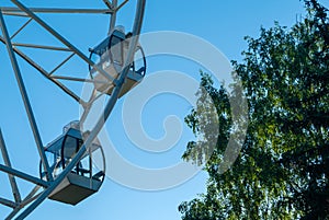 Ferris wheel booths in the city Park against the background of the morning blue sky