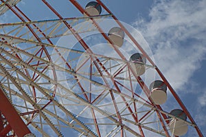 Ferris wheel on a bright sunny day. Brightly colored Ferris wheel against the cloudy sky