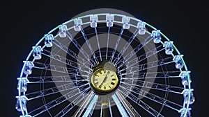 Ferris wheel for Christmas, behind the public Parliament clock in Bucharest, Romania, centered and symmetrical. Night timelapse.