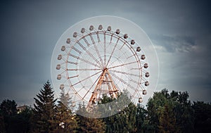 Ferris wheel with closed booths against the sky. Amusement Park on a summer day