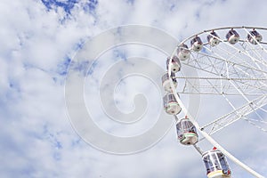 Ferris wheel with cloudy blue sky