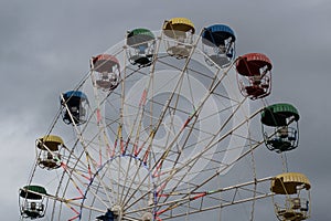 Ferris wheel with colorful booths in the amusement Park on the background of the stormy sky