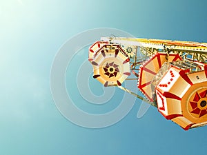 Ferris wheel with colorful cabins on the blue sky background