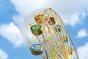 Ferris wheel with colorful colorful booths in the amusement Park the blue sky.