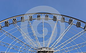 Ferris wheel, details, on clear blue sky background. Amusement park, festive mood