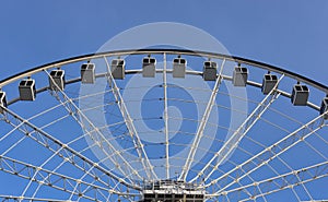 Ferris wheel, details, on clear blue sky background. Amusement park, festive mood