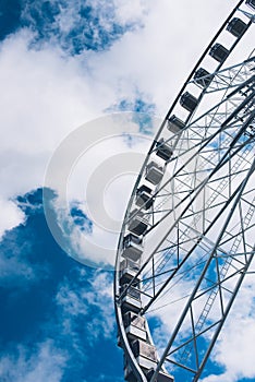 Ferris wheel details on a cloudy sky background