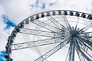Ferris wheel details on a cloudy sky background