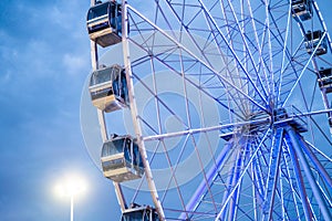 Ferris wheel in front of blue sky with clouds