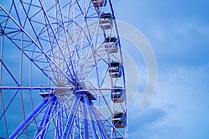 Ferris wheel in front of blue sky with clouds