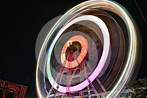 Ferris wheel or giant wheel over dark sky background during night time