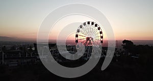 Ferris wheel on the green hill Kok Tobe at sunset