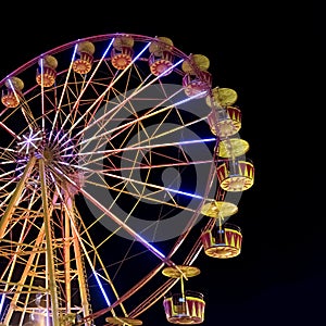 Ferris wheel with lights backlighting the night sky