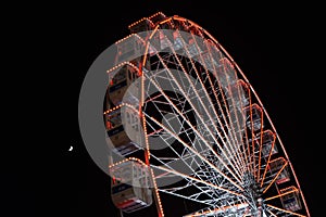 Ferris wheel and the moon. Black sky background.