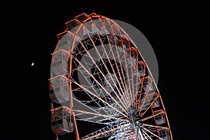 Ferris wheel and the moon. Black sky background.