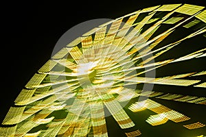 Ferris wheel in motion at the amusement park, night illumination. Long exposure