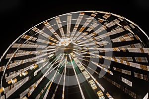 Ferris wheel in motion at the amusement park, night illumination. Long exposure