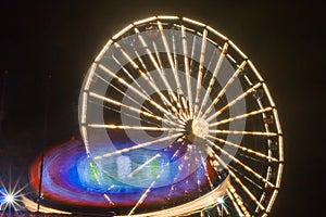 Ferris wheel in motion at the amusement park, night illumination. Long exposure