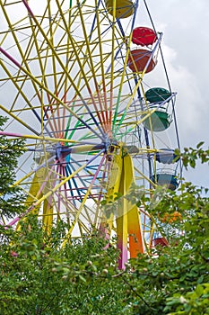 Ferris wheel with multi-colored booths in amusement park
