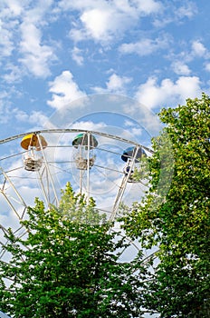 Ferris wheel with multi-colored booths. Vertical frame