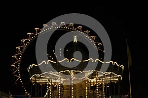 Ferris wheel at night, big wheel and carousel in lights