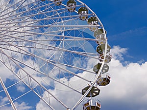 Ferris wheel in the park, a close-up view from the bottom against the blue sky. there is a place for the inscription