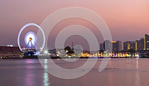 Ferris wheel river side at twilight time on Bangkok cityscape