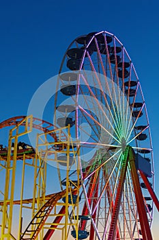 Ferris wheel and roller coaster illuminated at night on the pier in Ocean City, Maryland