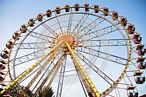 Ferris wheel and rollercoaster in motion at amusement park