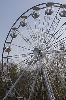 Ferris wheel with seats. The blue sky is in the background