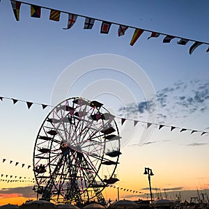 Ferris Wheel Silhouette against Orange Blue Sunset Sky in a Summer Night