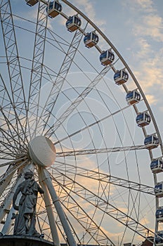 Ferris wheel at sunset with sculpture in Budapest, Hungary. 60 meters high giant ferris wheel stands in the city square.