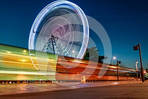 Ferris wheel and tram traces of light at dusk to down in Tours