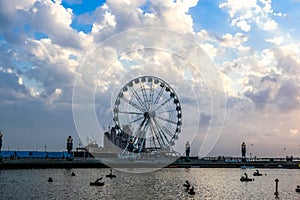 Ferris Wheel under Dramatic Sunrise and Sunset and cloudy sky, Nature background with strong sunbeam, Hope concept.