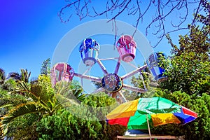 The Ferris wheel, which meets the blue sky, is circling among th