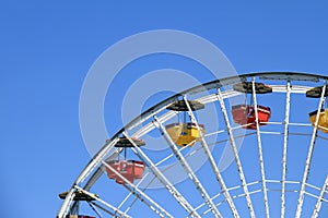 Ferris wheels over clear blue sky background at amusement park.