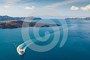 Ferry arrives at the port of Santorini Island, Greece. Blue sea and the blue sky with clouds