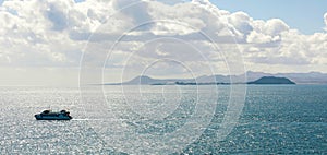 Ferry boat on Atlantic Ocean with Isla de Lobos and Fuerteventura islands on the background photo