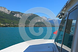 ferry boat crossing Annecy lake and mountains during summer