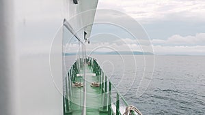 Ferry boat cursing on calm sea water with wave splashing on sunny day.