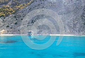 Ferry boat with tourists on Egremnoi beach, Lefkada island, Greece. Beautiful blue water. photo